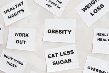 white paper cards with bold black text scattered on a light surface. The cards display health-related words and phrases