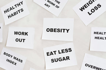 white paper cards with bold black text scattered on a light surface. The cards display health-related words and phrases
