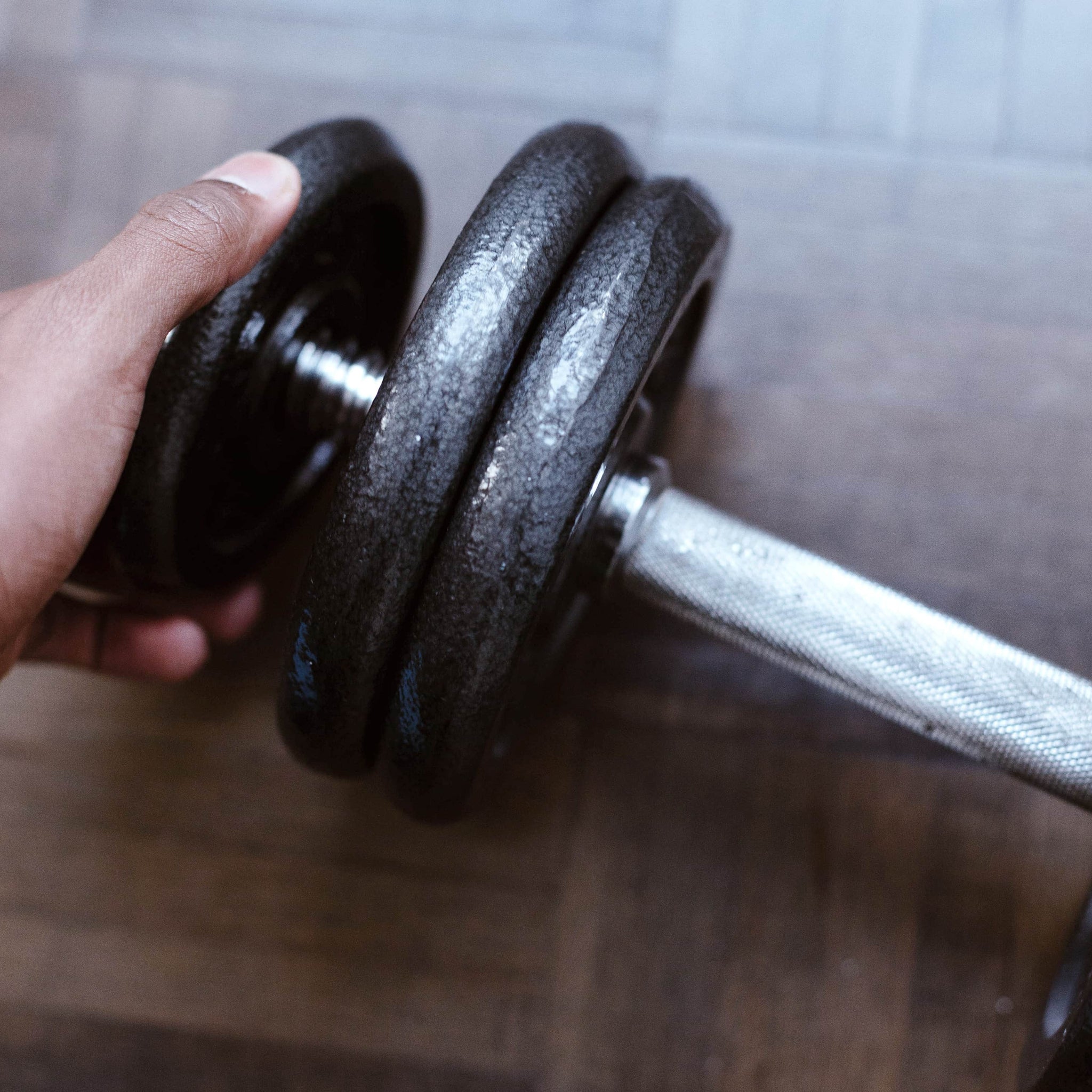 close up of a hand adding weight to a dumbbell