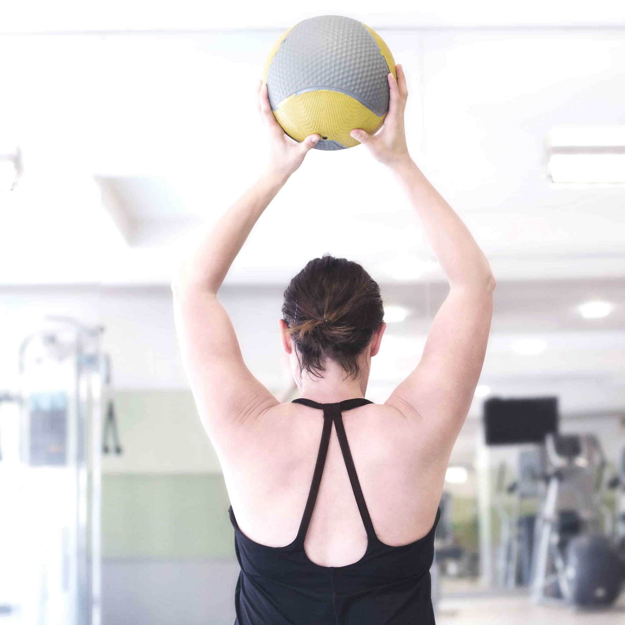 woman lifting fitness ball